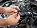 Mani che tengono un iniettore, componente essenziale per il corretto funzionamento del motore.