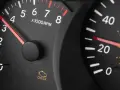 Cruscotto auto con spia motore accesa ma nessun problema. Tachimetro e contagiri visibili.