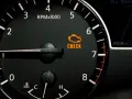Cruscotto auto con tachimetro e spia gialla motore accesa. Indica un problema da controllare.