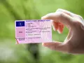 Mano che tiene una patente italiana, con dettagli su nome, data di nascita e scadenza. Nuove regole patente in arrivo?
