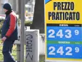 Prezzo praticato per la benzina: 2,429 €/litro. Un uomo in divisa osserva il cartello.