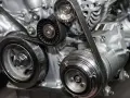 Dettaglio di un motore con cinghia a bagno d'olio, che mostra pulegge e componenti. Alcuni motori moderni utilizzano questo sistema.