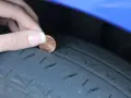 Dito un penny per controllare la spalla interna consumata del pneumatico. La profondità del battistrada è bassa.