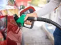 Mano che inserisce la pompa di benzina nel serbatoio di un'auto rossa. Attenzione a non mettere benzina nel diesel!