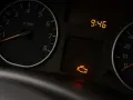 Cruscotto auto con tachimetro, orologio digitale e icona accesa del motore spia iniezione.
