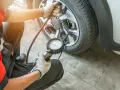 Meccanico controlla la pressione gomme, puntando a 3 bar per una guida sicura.