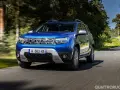 Dacia Duster blu in movimento su strada panoramica. Informazioni sul costo tagliando Dacia Duster.