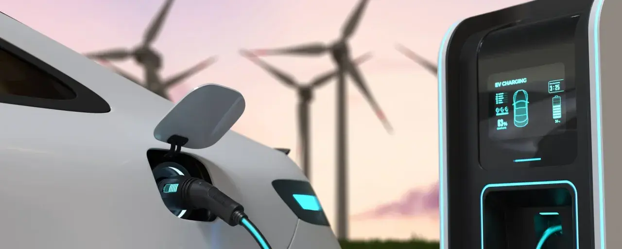 Auto elettrica in carica con turbine eoliche sullo sfondo. Un futuro sostenibile con il sogei bonus auto elettriche.