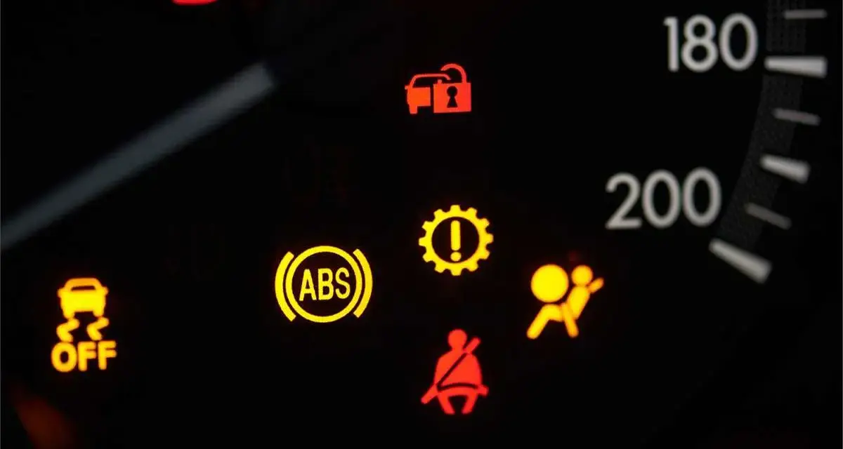 Cruscotto auto con spia ABS accesa fissa, insieme ad altre spie di avaria.