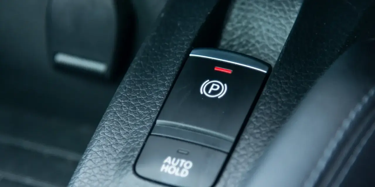 Pulsante freno a mano elettronico con spia rossa accesa e scritta "AUTO HOLD".