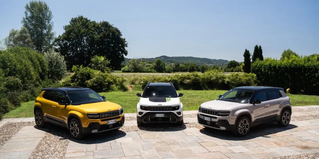 Tre Jeep Avenger, una gialla, una bianca e una grigia, parcheggiate all'aperto. Ottimi incentivi auto full hybrid per chi cerca un SUV ecologico.