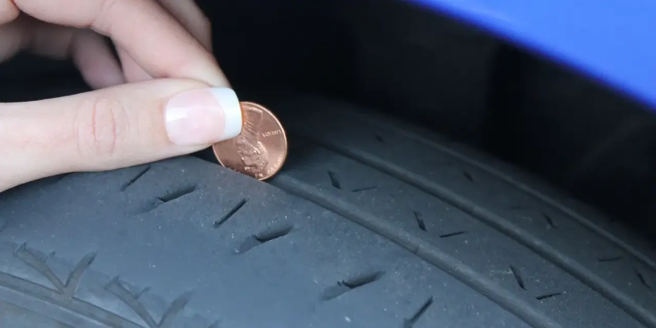 Dito un penny per controllare la spalla interna consumata del pneumatico. La profondità del battistrada è bassa.