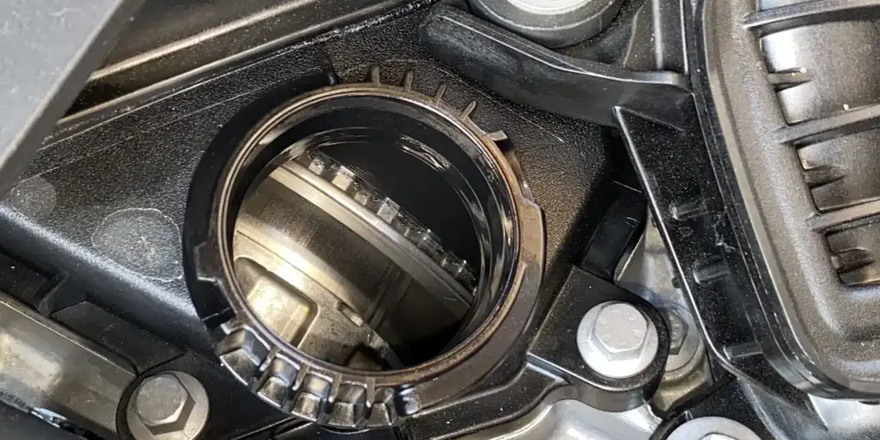 Dettaglio di un motore con una **cinghia a bagno d'olio** visibile all'interno di un alloggiamento metallico.