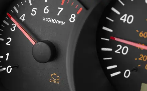 Cruscotto auto con spia motore accesa ma nessun problema. Tachimetro e contagiri visibili.