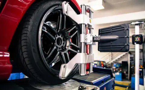 Ruota di un'auto rossa su un banco di prova per l'assetto ruote.