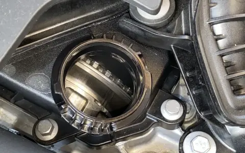 Dettaglio di un motore con una **cinghia a bagno d'olio** visibile all'interno di un alloggiamento metallico.