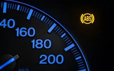 Cruscotto auto con spia ABS accesa. Indica la necessità di resettare spia ABS per ripristinare la sicurezza.