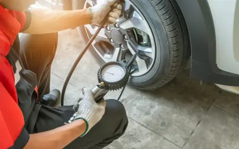 Meccanico controlla la pressione gomme, puntando a 3 bar per una guida sicura.
