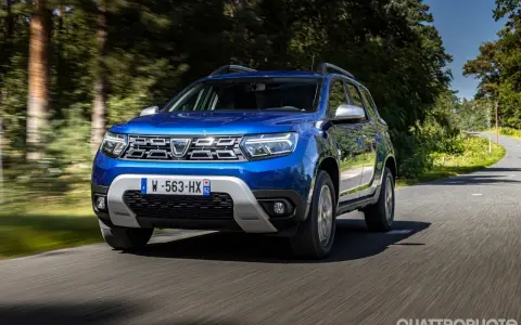 Dacia Duster blu in movimento su strada panoramica. Informazioni sul costo tagliando Dacia Duster.