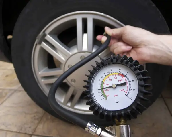 Controllo della pressione gomme Peugeot 208 con manometro. La lancetta indica un valore basso, necessario gonfiare.