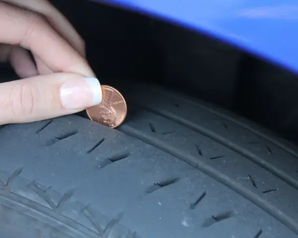 Dito un penny per controllare la spalla interna consumata del pneumatico. La profondità del battistrada è bassa.