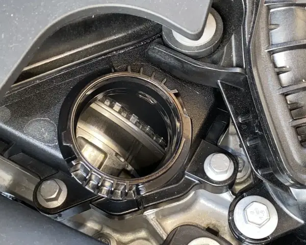 Dettaglio di un motore con una **cinghia a bagno d'olio** visibile all'interno di un alloggiamento metallico.