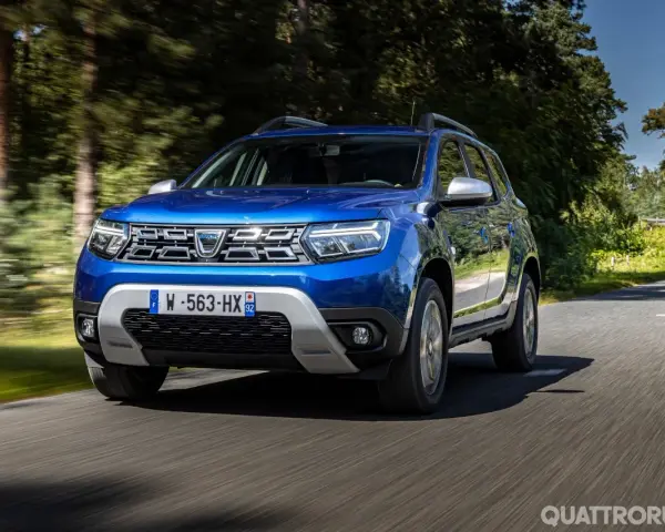 Dacia Duster blu in movimento su strada panoramica. Informazioni sul costo tagliando Dacia Duster.
