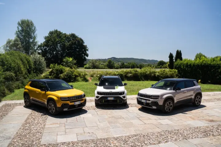 Tre Jeep Avenger, una gialla, una bianca e una grigia, parcheggiate all'aperto. Ottimi incentivi auto full hybrid per chi cerca un SUV ecologico.