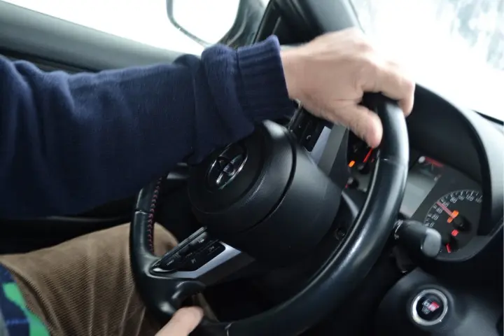 Mani sul volante, un promemoria su come guidare sulla neve: lentezza e dolcezza per affrontare le strade scivolose.