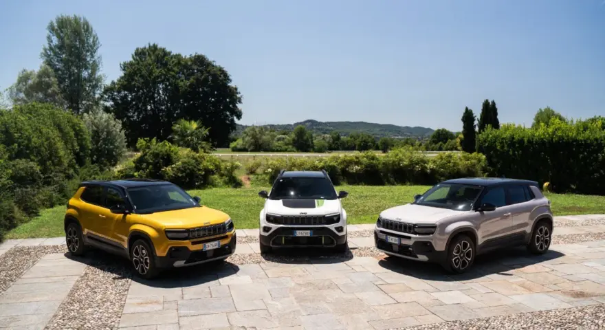 Tre Jeep Avenger, una gialla, una bianca e una grigia, parcheggiate all'aperto. Ottimi incentivi auto full hybrid per chi cerca un SUV ecologico.