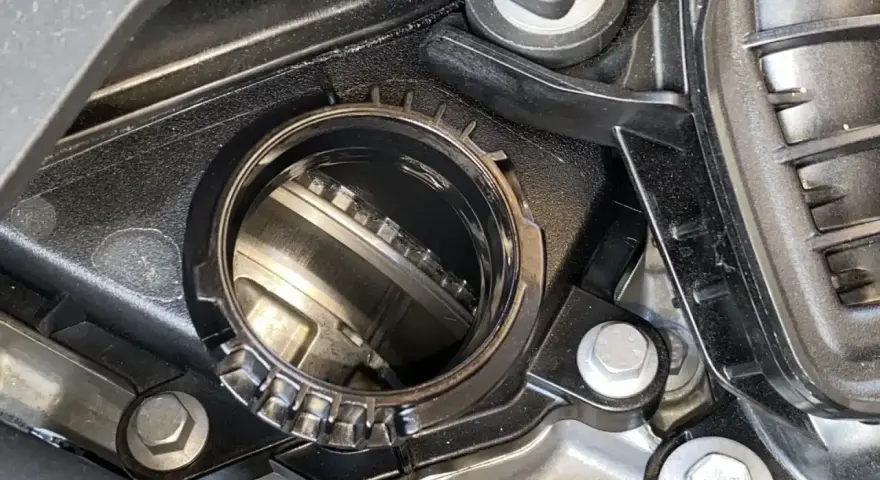 Dettaglio di un motore con una **cinghia a bagno d'olio** visibile all'interno di un alloggiamento metallico.