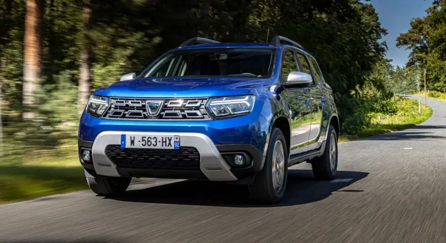 Dacia Duster blu in movimento su strada panoramica. Informazioni sul costo tagliando Dacia Duster.