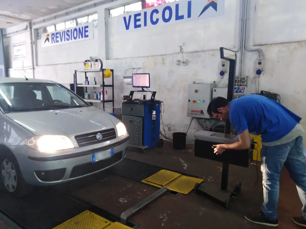 Un tecnico controlla un'auto in un centro revisioni. La domanda