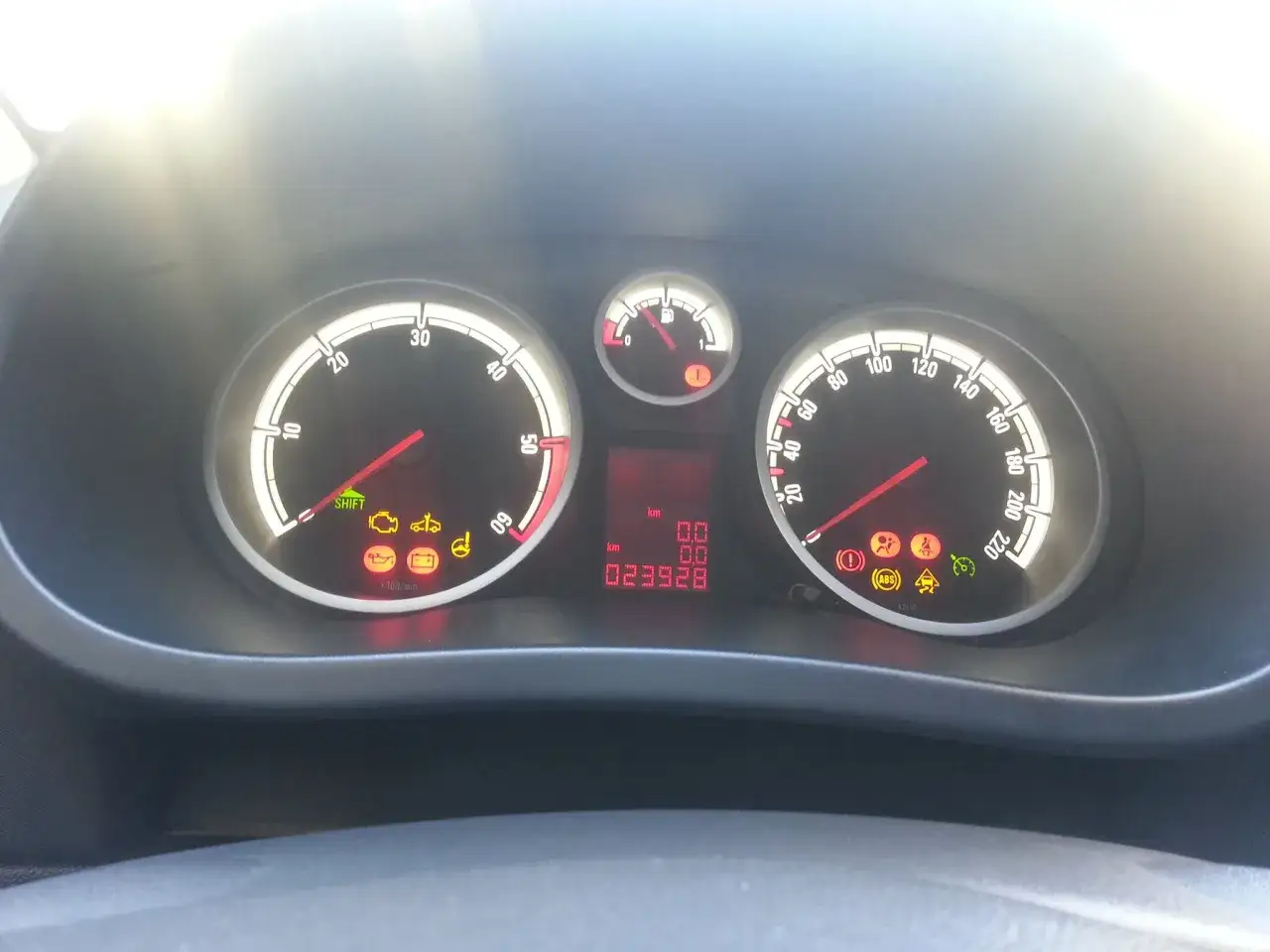 Cruscotto Opel Corsa con spie accese: motore, olio, batteria, ABS, ESP. Chilometraggio 23928 km.