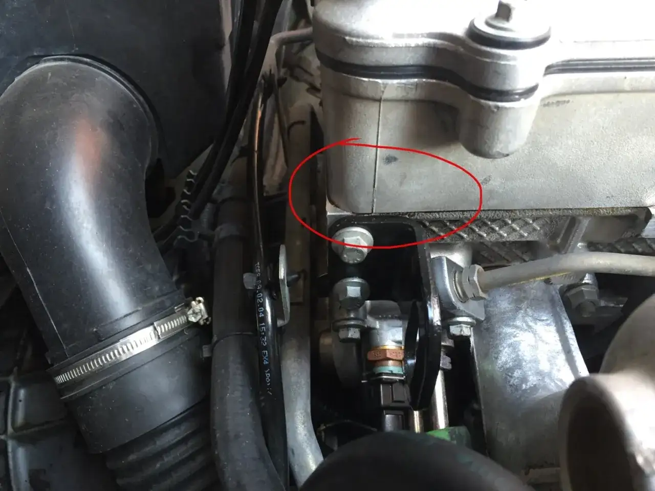 Evidenza di una macchia di olio motore dalla testata, indicando una potenziale perdita.