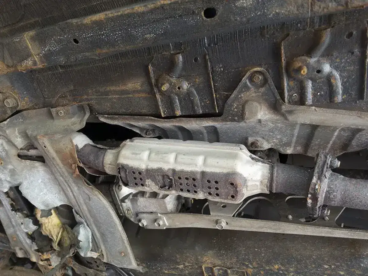 Sottoscocca auto con catalizzatore arrugginito. Il catalizzatore serve a ridurre le emissioni nocive dei gas di scarico.