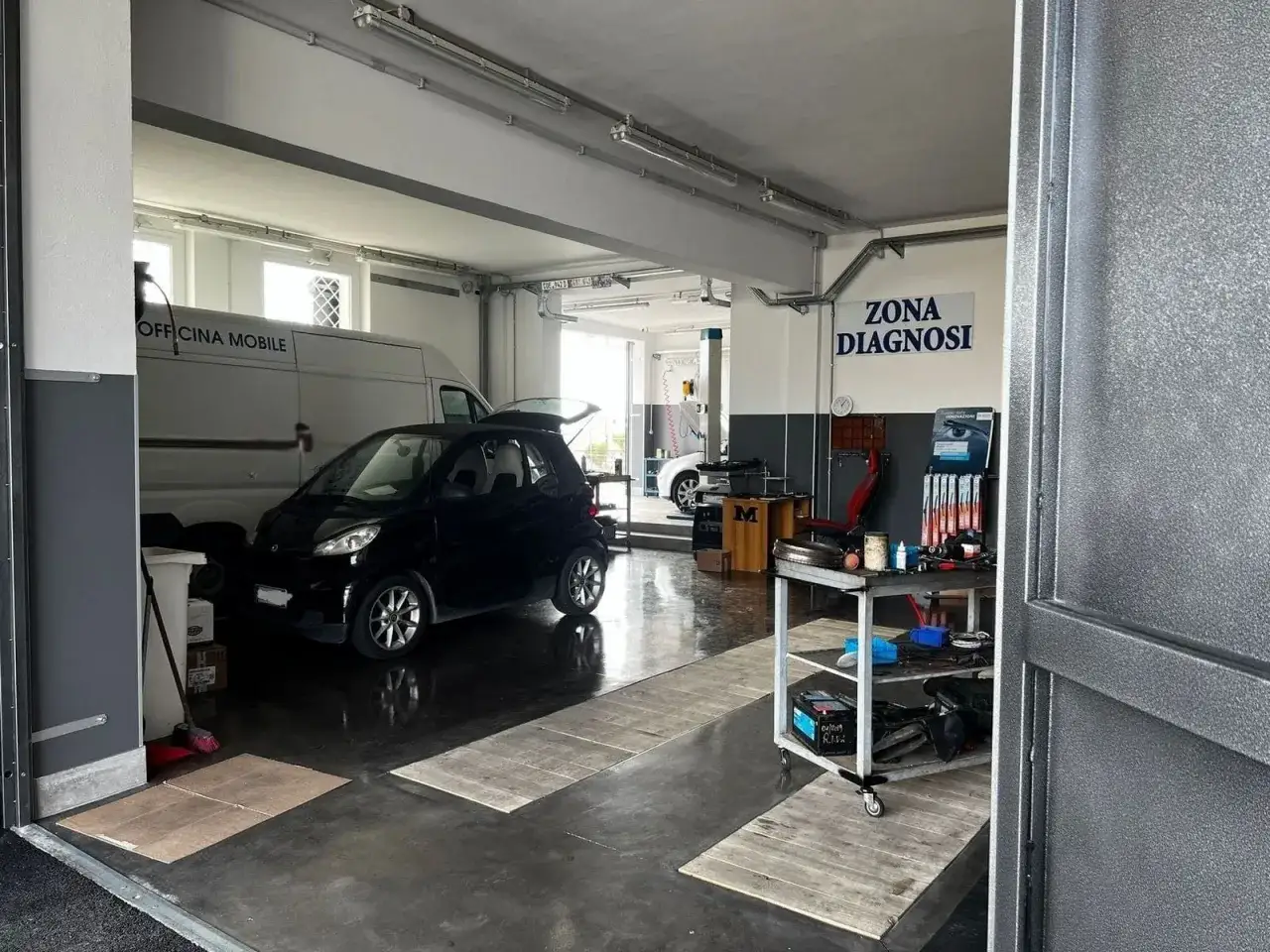 Officina elettrauto: diagnosi e riparazioni auto. Qui si vede un'auto piccola in riparazione, con attrezzature per elettrauto.