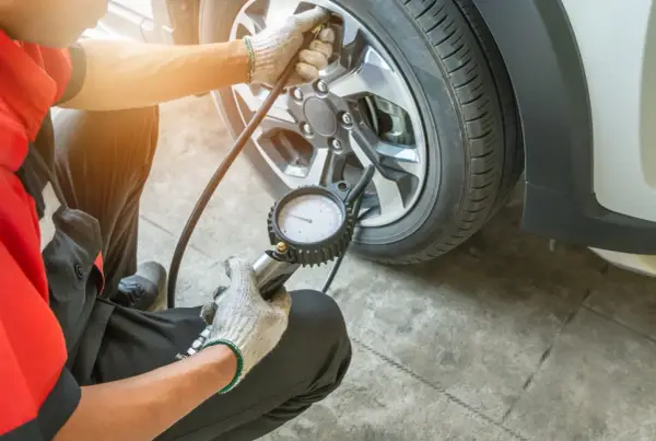 Meccanico controlla la pressione gomme, puntando a 3 bar per una guida sicura.