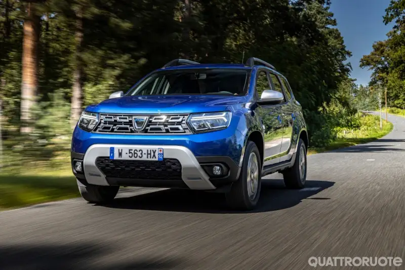 Dacia Duster blu in movimento su strada panoramica. Informazioni sul costo tagliando Dacia Duster.